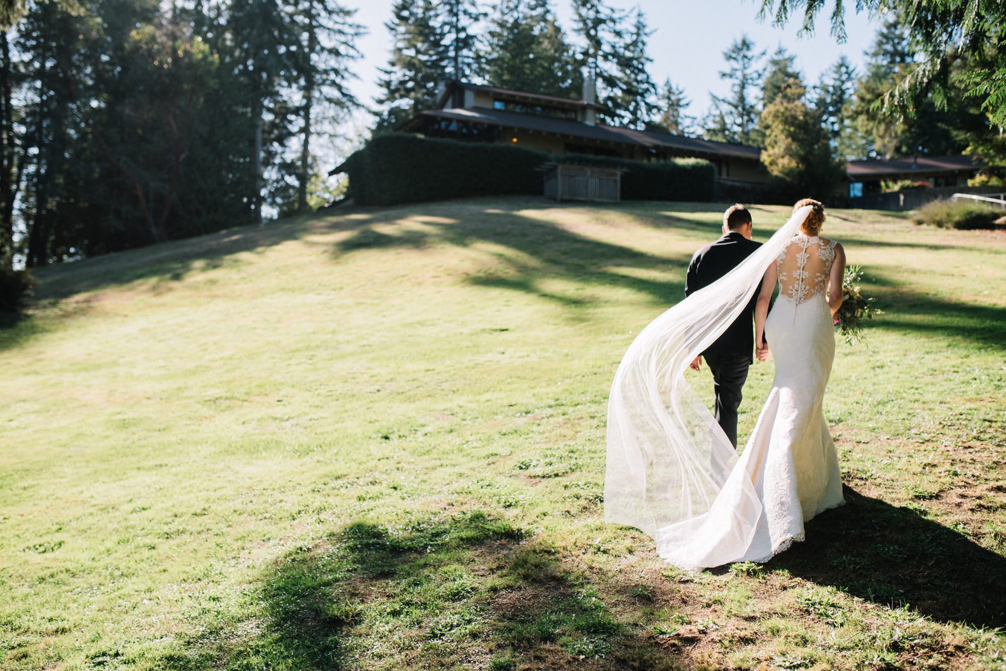 Katherine's veil dances in the wind as she and Graeme walk away from their wedding ceremony at Kingston House, WA.