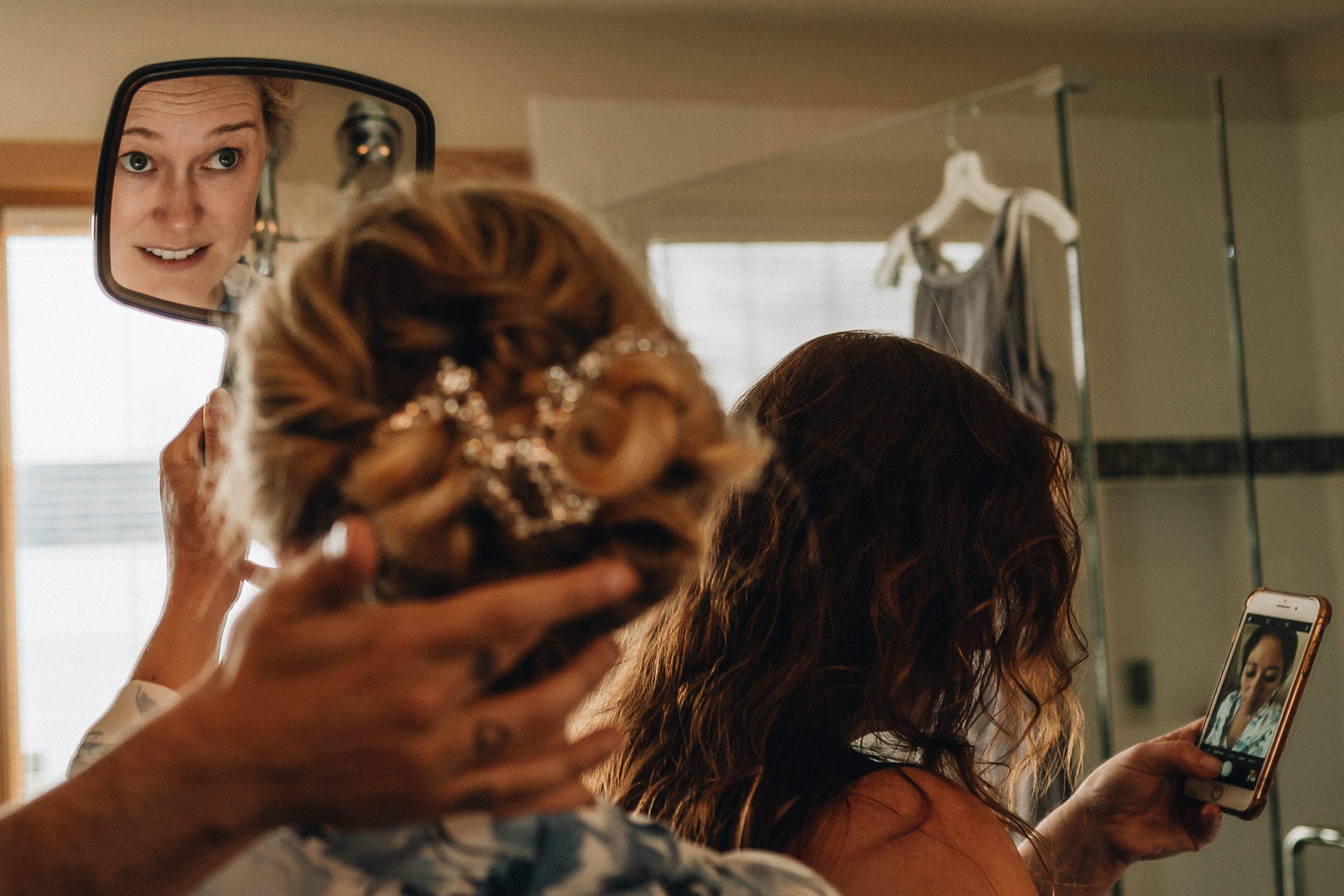 Boatyard Inn Weddings on Whidbey Island: Sara's mom looks on while Sara checks her hair 