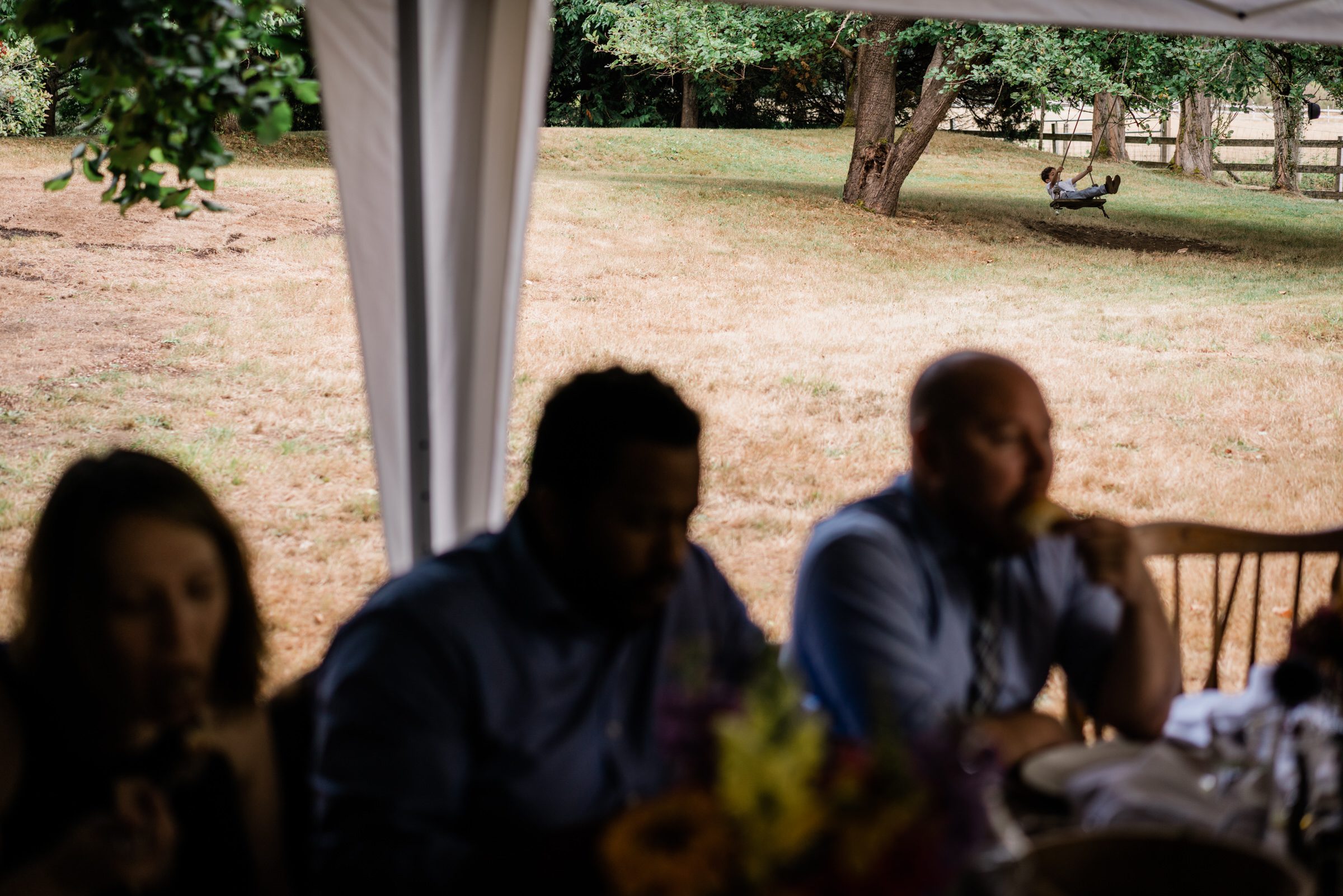 Wayfarer Whidbey Island Wedding: A wedding groomsmen swings from a nearby tree at the wedding