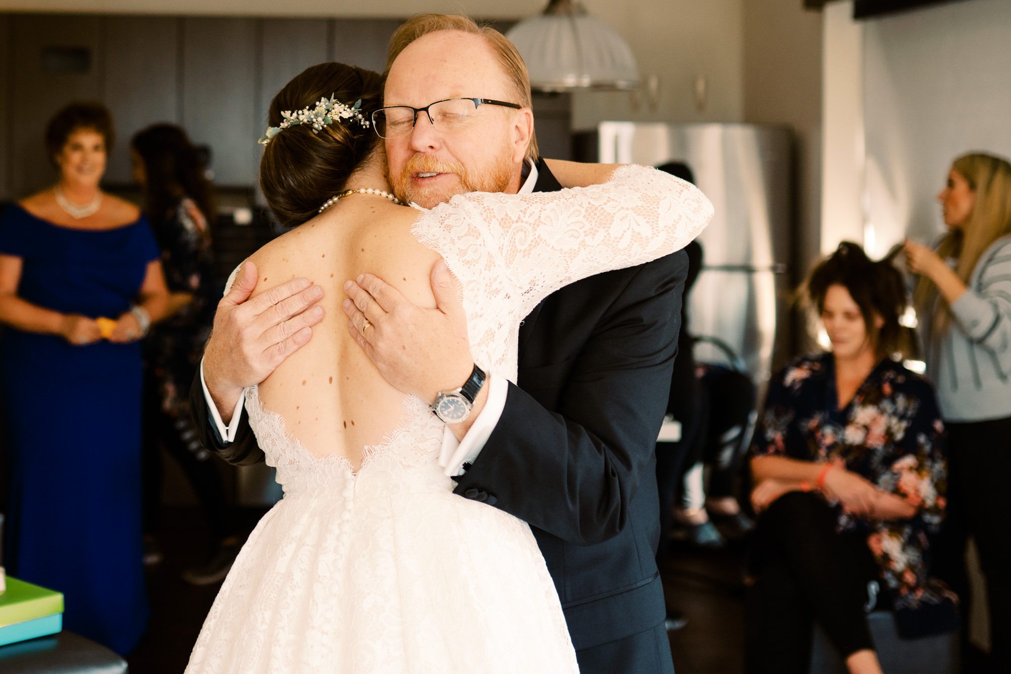 Father of the bride gives her a hug