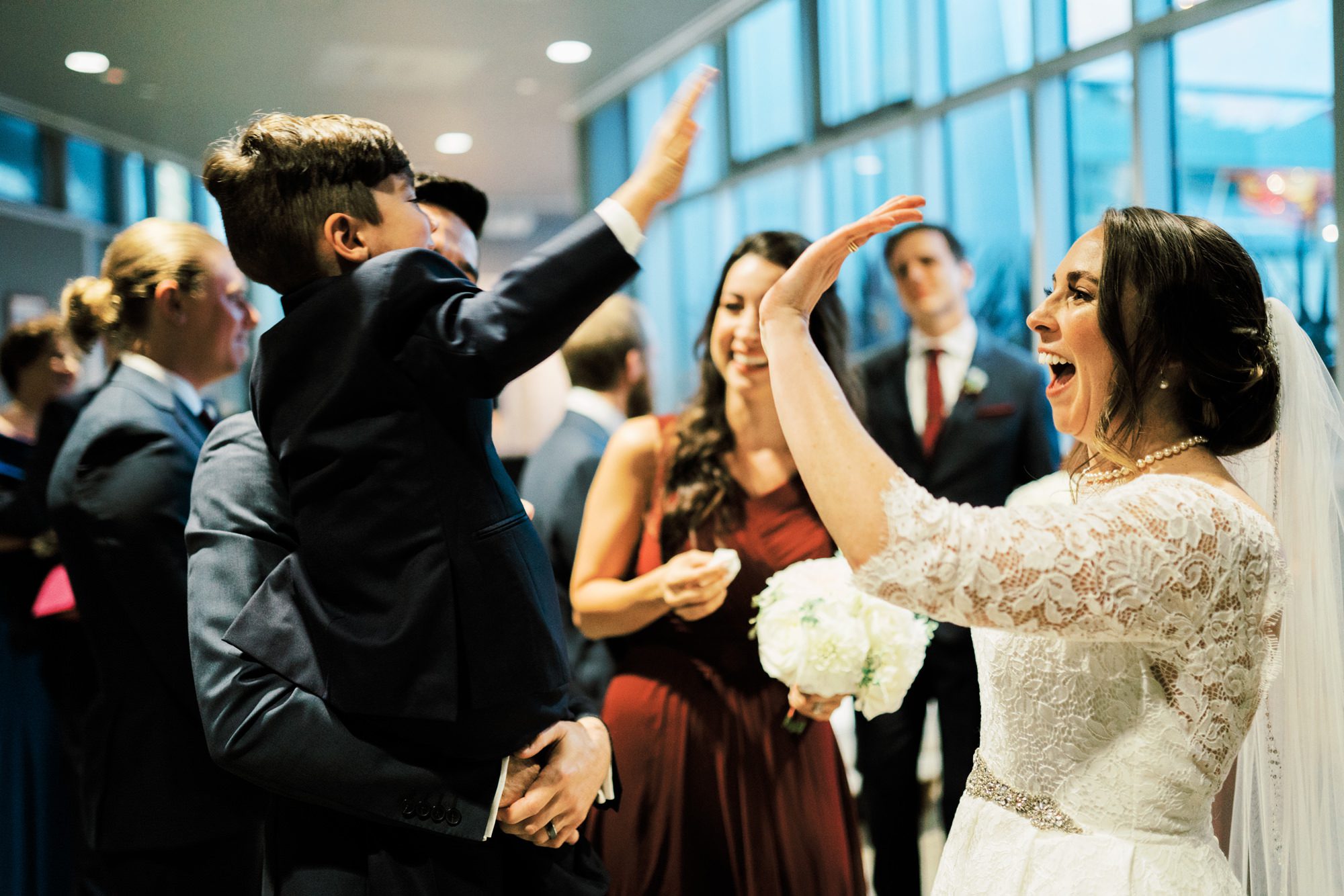 Bride and ringbearer high five after the wedding