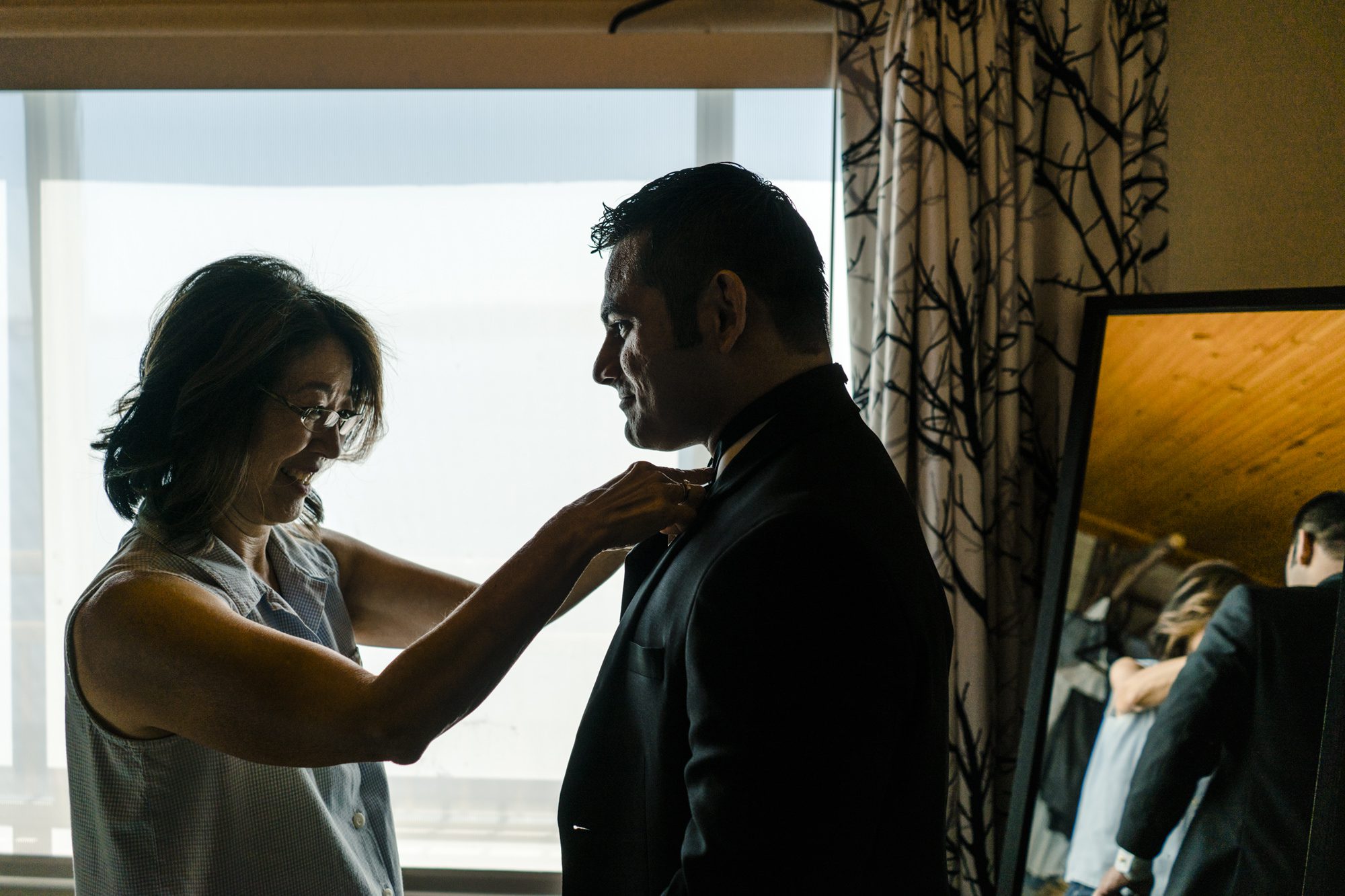 Mother of the bride helps groom Ash with his bowtie. 