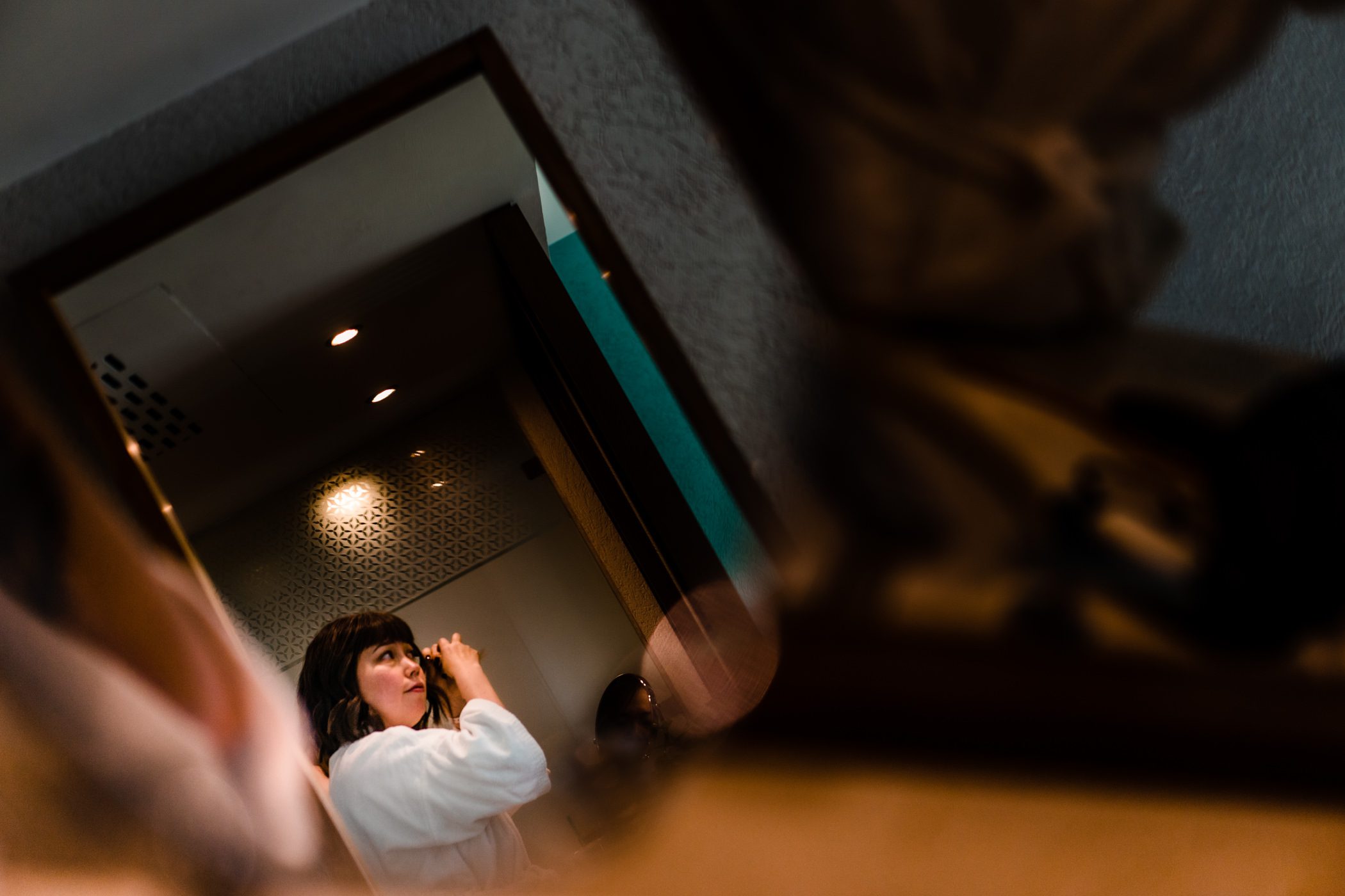 Bride Faythe curls her hair in preparation for her wedding.
