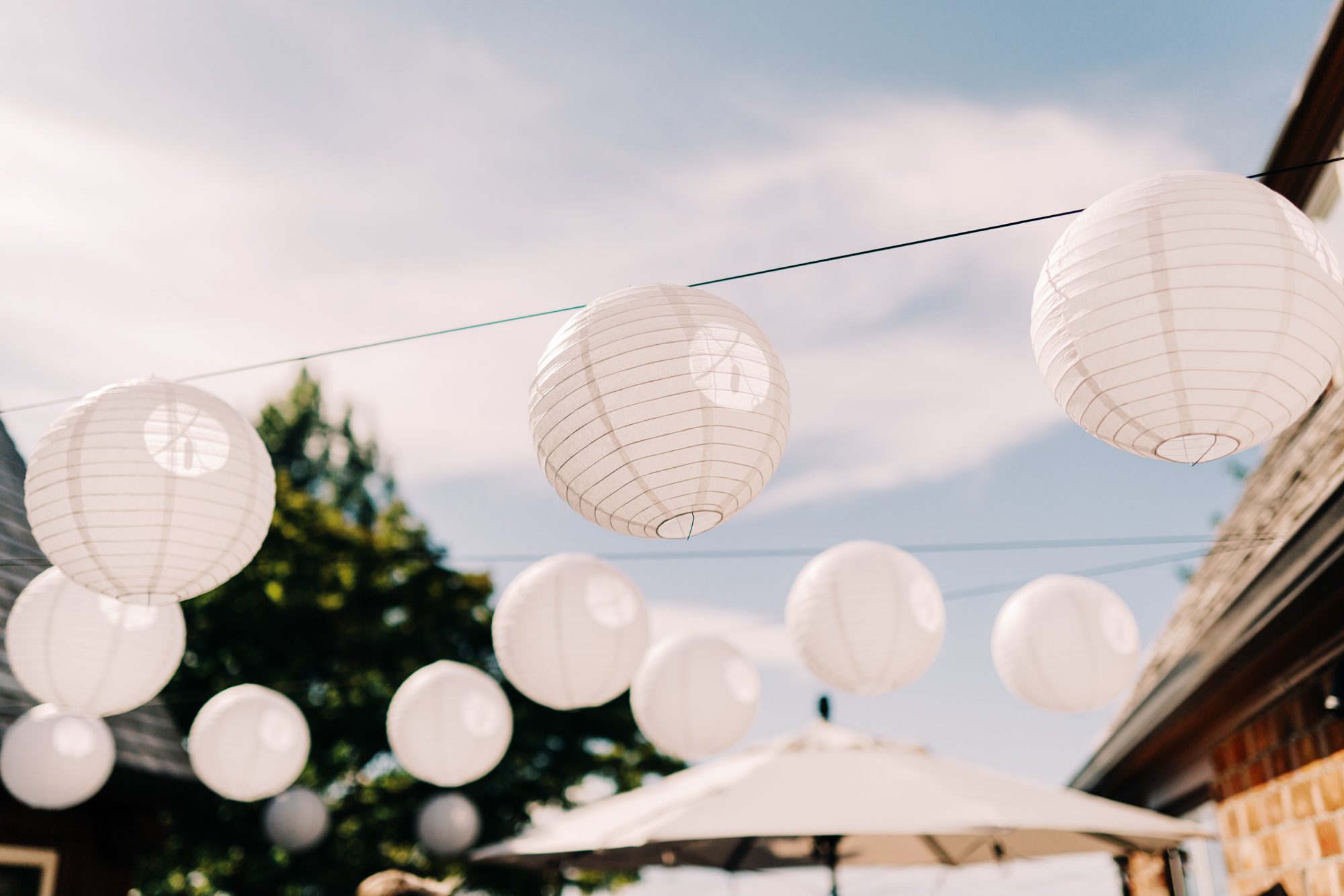 White lanterns decorate Jen and Sage's wedding