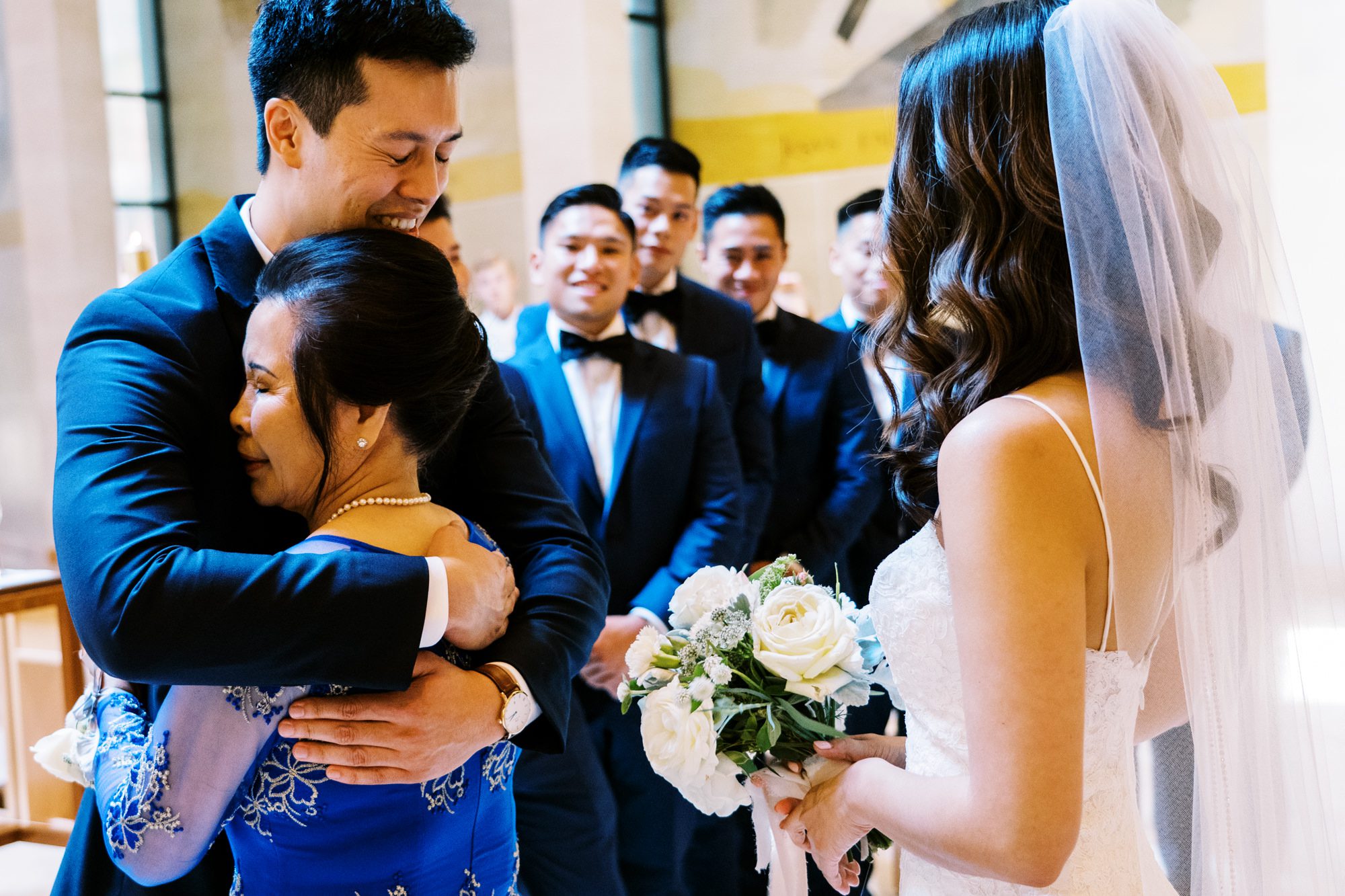 St Anne's Catholic Church wedding: Groom and mom of bride hug