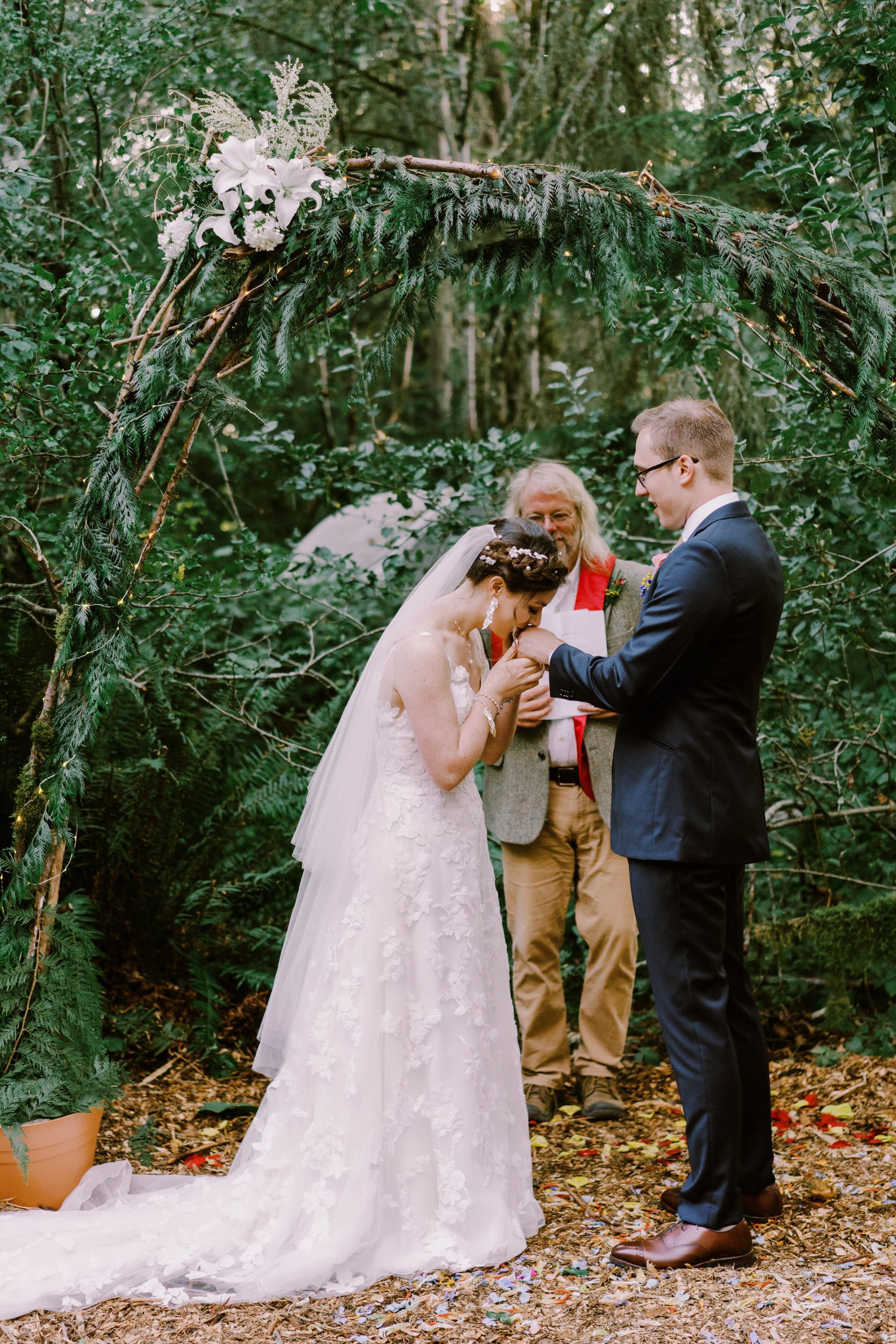 Annika kisses her groom Sean's hand during their wedding ceremony.