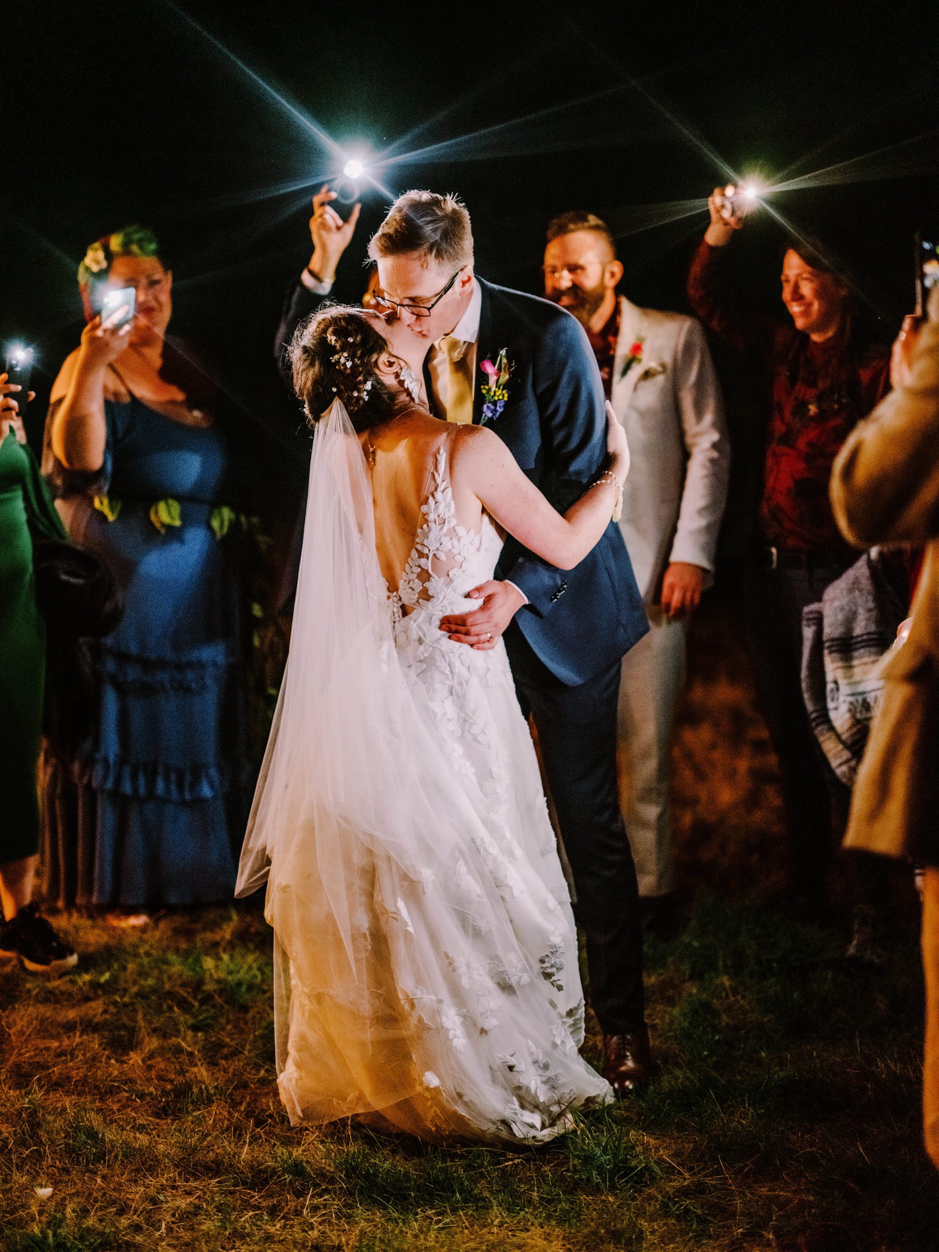 Annika and Sean's first dance lit by their friends and family's phones.